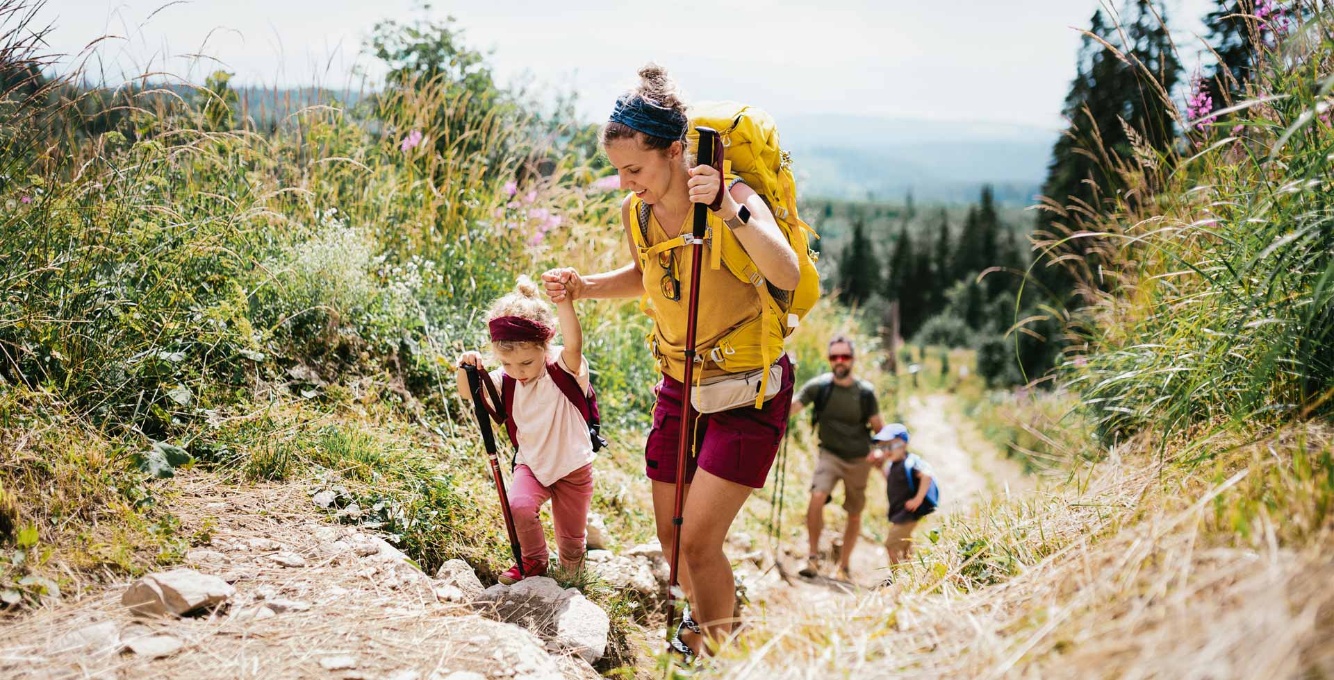 Experience unforgettable family moments with the Family Time offer at TRIFORÊT alpin.resort. A family of four goes on a hiking trip in the natural surroundings of Hinterstoder.